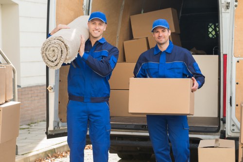 Removal van and moving team beside residential flats in New Cross