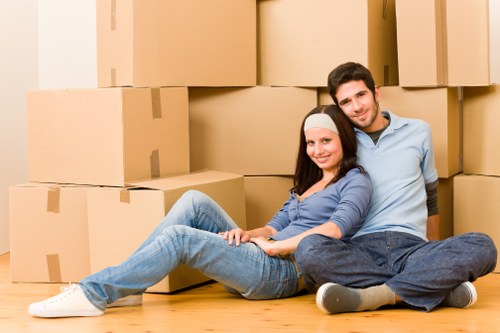 Movers carrying household items down stairs in New Cross