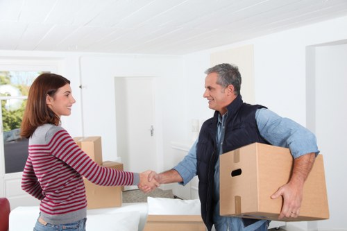 Movers carrying boxes through a New Cross residential property